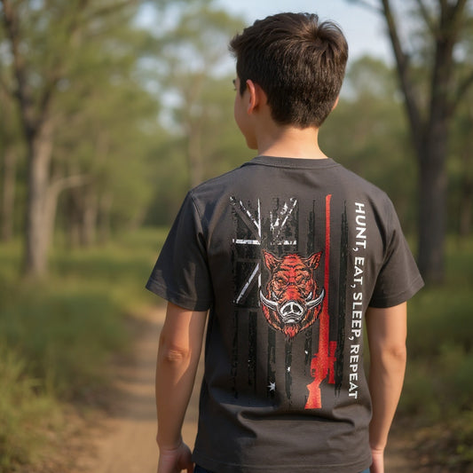 Young adventurer wearing AWTB Apparel kids Hunt, Eat, Sleep, Repeat tee outdoors”