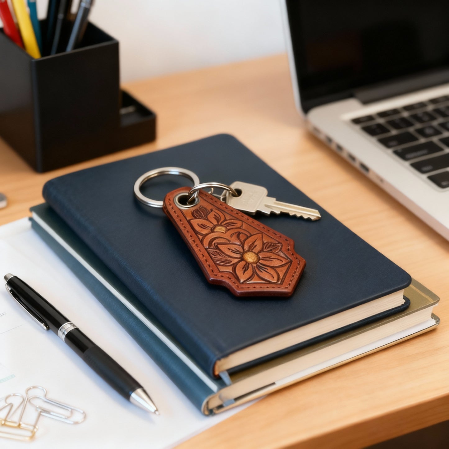 Floral embossed leather keychain styled with autumn leaves