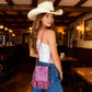 Woman wearing mini tassel bag crossbody with adjustable leather strap