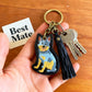 Close-up detail of painted cattle dog keychain with leather tassel