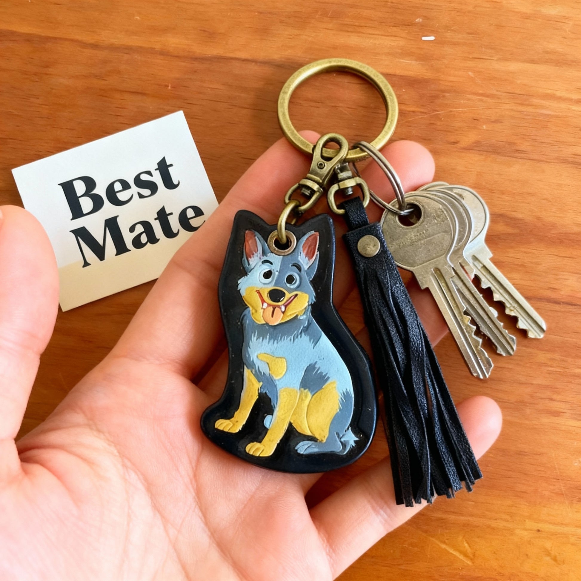 Close-up detail of painted cattle dog keychain with leather tassel